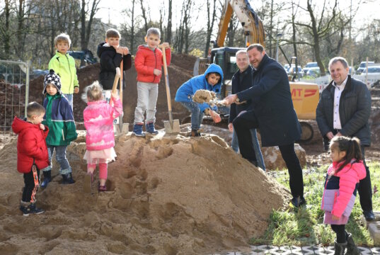 Oberbürgermeister Tim Kurzbach griff am Dienstag zum Spaten und vollzog den symbolischen ersten Spatenstich der neuen Kita am Klinikum. Unterstützt wurde er dabei von Kindern der benachbarten Kita Lucasstraße sowie von SEG-Chef Carsten Zimmermann (re.) und Andreas Budde. (Foto: © Bastian Glumm)