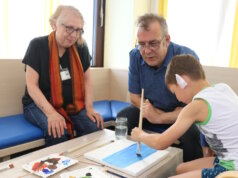 Klinikum-Patientenfürsprecherin Birgit Correns und Künstler Carsten Wecke malen emeinsam mit einem jungen Patienten ein Bild. (Foto: © Bastian Glumm)