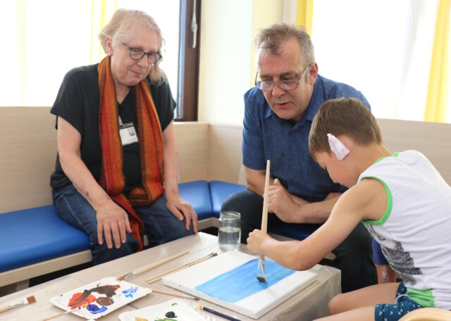 Klinikum-Patientenfürsprecherin Birgit Correns und Künstler Carsten Wecke malen emeinsam mit einem jungen Patienten ein Bild. (Foto: © Bastian Glumm)