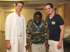 Nach überstandener Operation kämpft sich Steven Jacob Amunga (mi.) Schritt für Schritt in ein Leben ohne Behinderung. An seiner Seite: Dr. Oliver Voß (li.), Oberarzt der Klinik für Unfallchirurgie, Orthopädie und Handchirurgie, und Physiotherapeut Michele Lorenzo Patricelli. (Foto: © Bastian Glumm)