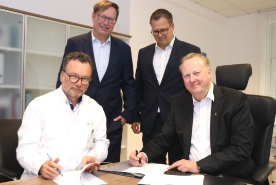 Unterzeichneten jetzt den Vertrag für den Neubau des Parkhauses an der Gotenstraße: Die Klinikum-Geschäftsführer Prof. Dr. Thomas Standl (li.) und Prof. Dr. Martin Eversmeyer (sitzend) mit Sven Schmidtke (li.) und Ralph Stasch von Goldbeck. (Foto: © Bastian Glumm)