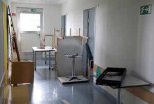Ausgeräumte Möbel im Klinikflur: Vor dem Rückbau von Haus G wird Inventar für die Mitnahmeaktion bereitgestellt. (Foto: © Bastian Glumm)