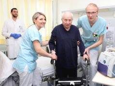 Hermine Harder (li.) und Philipp Röltgen (re.) helfen einem Patienten der St. Lukas Klinik. Im Hintergrund Assistenzarzt Tariq Al-Hindi. (Foto: © Kplus Gruppe)