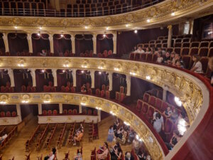 Im Inneren beeindruckt das Theater mit einem hufeisenförmigen Zuschauerraum, goldverzierten Decken, schweren roten Vorhängen und einem eindrucksvollen und überaus schweren Kristallleuchter. (Foto: © Bastian Glumm)