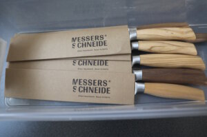 Frisch geschärfte Messer von „Messers Schneide“ mit Holzgriffen, verpackt in Schutzmanschetten – bereit für den Versand an Kundinnen und Kunden. (Foto: © Bastian Glumm)