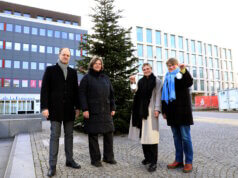 Solingen: Mitteschmiede präsentiert Weihnachtsbaum auf dem Neumarkt Von links: Dr. Guido Eusani und Nicole von Mueller (Mitteschmiede), Lorena Glatz (Stadt-Sparkasse Solingen) und Ulrike Kilp (Diakonie Solingen) vor dem erstmals auf dem Neumarkt aufgestellten Weihnachtsbaum. (Foto: © Bastian Glumm)