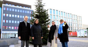 Solingen: Mitteschmiede präsentiert Weihnachtsbaum auf dem Neumarkt Von links: Dr. Guido Eusani und Nicole von Mueller (Mitteschmiede), Lorena Glatz (Stadt-Sparkasse Solingen) und Ulrike Kilp (Diakonie Solingen) vor dem erstmals auf dem Neumarkt aufgestellten Weihnachtsbaum. (Foto: © Bastian Glumm)