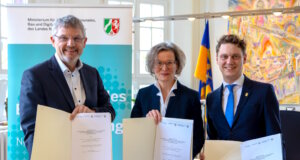 Solingen: Rathaus testet KI‑Verwaltungsassistenz NRW.Genius Ina Scharrenbach, Ministerin für Heimat, Kommunales, Bau und Digitalisierung des Landes Nordrhein-Westfalen, Dr. Dirk Weckendrup (li.), Vizepräsident von IT.NRW, und Solingens Oberbürgermeister Daniel Flemm unterzeichnen die Vereinbarung zur Teilnahme am KI-Pilotprojekt „NRW.Genius“. (Foto: © Stadt Solingen)