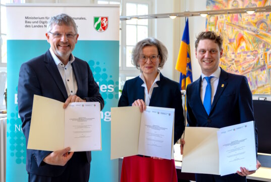 Ina Scharrenbach, Ministerin für Heimat, Kommunales, Bau und Digitalisierung des Landes Nordrhein-Westfalen, Dr. Dirk Weckendrup (li.), Vizepräsident von IT.NRW, und Solingens Oberbürgermeister Daniel Flemm unterzeichnen die Vereinbarung zur Teilnahme am KI-Pilotprojekt „NRW.Genius“. (Foto: © Stadt Solingen)