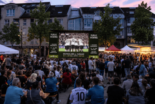 Zum Auftakt der Fußball-Weltmeisterschaft 2026 wird auf dem Ohligser Marktplatz das erste Gruppenspiel der deutschen Nationalmannschaft gegen Curaçao live auf Großbildleinwand übertragen. (Symbolbild/KI-Visualisierung)