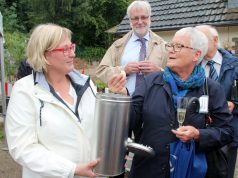 PHoS-Vorsitzende Cordula Scheffels (li.) sammelte gestern kleine symbolische Geschenke in einer Metalldose, die demnächst im Innenhof des Hospizneubaus vergraben wird. Auch Sabine Schulz-Wolff von der Stiftung Botanischer Garten hatte eine Kleinigkeit dabei. PHoS-Vorstandsmitglied Ludger Hoebink schaute den Damen über die Schultern. (Foto: © B. Glumm)