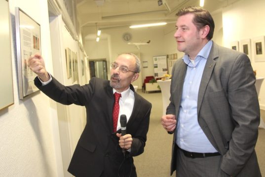 Oberbürgermeister Tim Kurzbach (re.) im Flur des 1. Obergeschosses im Rathaus-Altbau, der sich bestens als Ausstellungsraum für Künstler eignet. Hachimi Azza erläutert Details seiner Radierungen. (Foto: © B. Glumm)