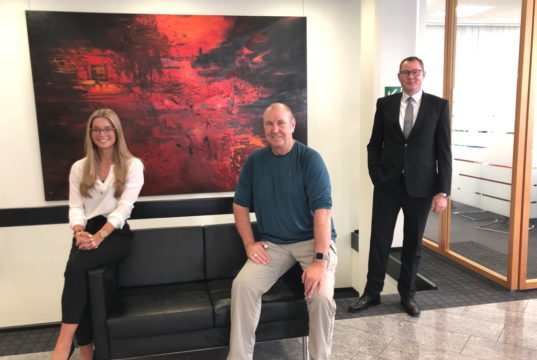 Künstler Peter Wischnewski (mi.) stellt in den Räumen der Volksbank-Filiale in Ohligs aus. Sehr zur Freude von Kundenberaterin Henriette Juliane May und Filialleiter Stefan Röhrig. (Foto: © city-art-project)