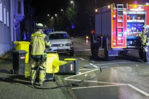 Ein Feuerwehrmann löscht brennende Müllcontainer am Straßenrand. Neben Fahrzeug- und Containerbränden musste die Feuerwehr in der Silvesternacht wiederholt gegen mutmaßlich vorsätzliche Brandstiftungen vorgehen. (Foto: © Tim Oelbermann)