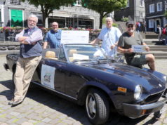 Friedensdorf-Botschafter Uli Preuss (li.) und Teamkollege Jürgen Beu (re.) nehmen mit einem Fiat Spider an der Six Bridges Rally teil. Eine Spende für das Friedensdorf in Höhe von 2.000 Euro überreichten jetzt Marc Schneider (2.v.l.) und Rene Splitthoff vom Rotary Club Solingen. (Foto: © Bastian Glumm)