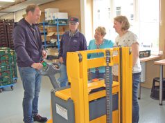 Vorwärts, rückwärts, lenken, heben und senken: Der Stapler steuert sich über multifunktionale Tasten an der Deichsel. Torsten Mitschelin erklärte die Handhabung Werner Fischer, der Tafel-Vorsitzenden Brigitte Funk und Alexandra Krug. Frau Krug wird auf den sachgerechten Umgang mit der im Wortsinn "entlastenden" Spende nun achten. (Foto: © Solinger Tafel)