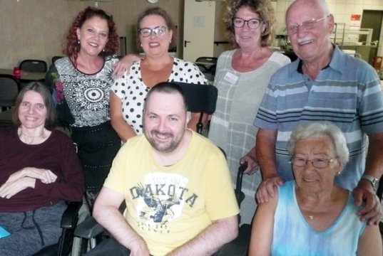 Beste Stimmung im Jubiläumsjahr: Heike Reischmann, Leiterin St. Joseph MS-Wohnbereich Karin Müller, Leiterin St. Joseph Wohnpark, Birgitt Jansen, Leiterin St. Joseph Altenheim, Rudi Vollak (hintere Reihe v.li.n.re.), Eva Jauß, Mario Rago und Regina Schmer (vordere Reihe, v.li.n.re.) im Speisesaal des St. Joseph Wohnparks. (Foto: © Kplus Gruppe)