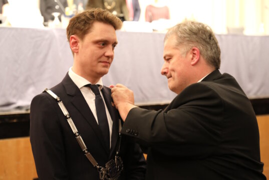 Oberbürgermeister Daniel Flemm (CDU) trug am Donnerstagabend erstmals seine Amtskette. CDU-Fraktionsvorsitzender Carsten Voigt hängte sie ihm um und richtete sie bei der Amtseinführung im Konzertsaal. (Foto: © Bastian Glumm)