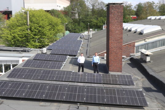 Adrian Dogge (li.), Leiter Planung bei der Stadtwerke Solingen GmbH, und Uwe Asbach, Vorstandsmitglied der BürgerEnergie Solingen, inmitten der neuen Solaranlager auf dem Hallendach auf dem SWS-Betriebshof an der Weidenstraße. (Foto: © Bastian Glumm)