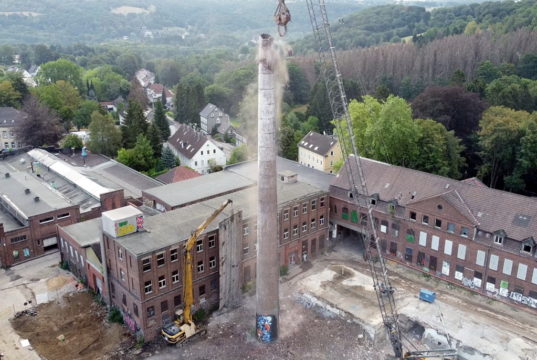 Auf dem ehemaligen Rasspe-Gelände in Stöcken wurde jetzt der rund 50 Meter hohe Kamin mit seiner Schlotöffnung von rund zwei Metern Durchmesser rückgebaut. (Foto: © Wirtschaftsförderung Solingen)