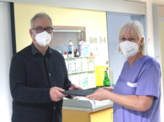 Gerhard Rassmann (Stellvertretender Vorsitzender Klinisches Ethikkomitee am Städtischen Klinikum) übergibt das erste Tablet an Uta Naumann, Gruppenleitung der internistischen Intensivstation F01. (Foto: © K. Morawietz/Klinikum Solingen)