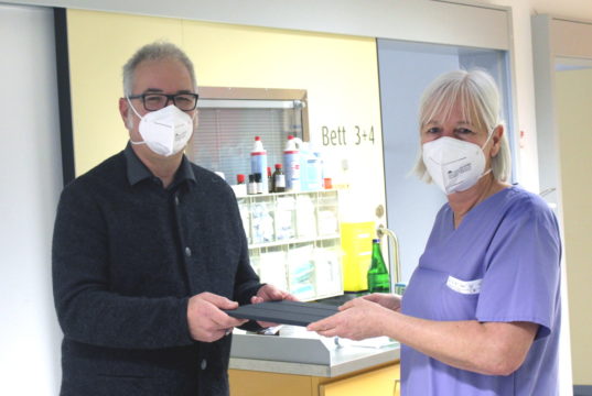 Gerhard Rassmann (Stellvertretender Vorsitzender Klinisches Ethikkomitee am Städtischen Klinikum) übergibt das erste Tablet an Uta Naumann, Gruppenleitung der internistischen Intensivstation F01. (Foto: © K. Morawietz/Klinikum Solingen)