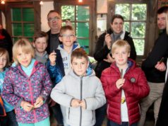 Stolz wie Oskar: Kinder und Erwachsene ziegen ihre Taschenmesser, die sie am Freitag in der Reiderei Lauterjung selbst gebaut haben. Scherenschleifer Jürgen Schrage (hinten) vom Industriemuseum führte durch den Kurs. (Foto: © B. Glumm)
