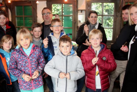 Stolz wie Oskar: Kinder und Erwachsene ziegen ihre Taschenmesser, die sie am Freitag in der Reiderei Lauterjung selbst gebaut haben. Scherenschleifer Jürgen Schrage (hinten) vom Industriemuseum führte durch den Kurs. (Foto: © B. Glumm)