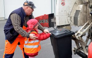 Es ist gar nicht so einfach, die Mülltonnen in die Vorrichtung am Müllwagen einzuhängen. Doch mit etwas Hilfestellung haben es alle Kinder geschafft. (Foto: © Martina Hörle)