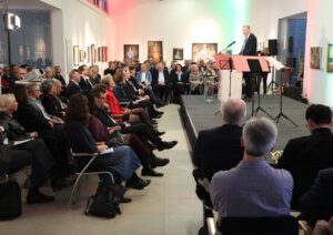Geschäftsführer Prof. Dr. Martin Eversmeyer, der das Klinikum in den vergangenen Jahren gemeinsam mit Prof. Dr. Thomas Standl geführt hat, spricht am Pult vor dem voll besetzten Meistermann-Saal im Kunstmuseum. (Foto: © Bastian Glumm)