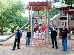 Daumen hoch für das neue Spielgerät auf dem Engelsberger Hof: vorne von links Klaus Podubrin, Silke Baersch, Stefan Röhrig und Uli Baersch sowie auf dem Klettergerüst Henri, Jonas, Carolina und Marie. (Foto: © Volksbank/Anne Stahl)