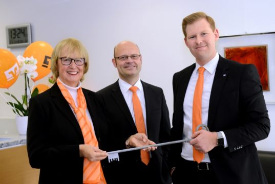 Leitungswechsel bei der Volksbank im Bergischen Land in Solingen-Wald: Die langjährige Filialleiterin Gudrun Berger und Marktbereichsleiter Eric Brühne (mi.) geben den Filialschlüssel symbolisch an Steffen Stocki (re.) weiter. (Foto: © Volksbank/Bettina Osswald)