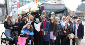 Teilnehmer und Projektbeteiligte bei der Auftaktfahrt der neuen O-Bus-Quiztour am Graf-Wilhelm-Platz: mit dabei Kater Salabim (im Kostüm: Sandra Kratz), Schirmherrin Sonja Flemm (li. daneben), Bürgermeisterin Ioanna Zacharaki (re. neben dem Kater) sowie Sandra-Janine Schneider (7. v. rechts) vor dem Sonderwagen der Linie 681. (Foto: © Bastian Glumm)