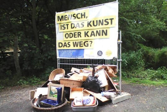 Auf dem Wanderparkplatz an der Westhausener Straße markierten die TechnischenBetriebe jetzt erstmals eine wilde Kippe mit einem Banner. (Foto: © TBS)